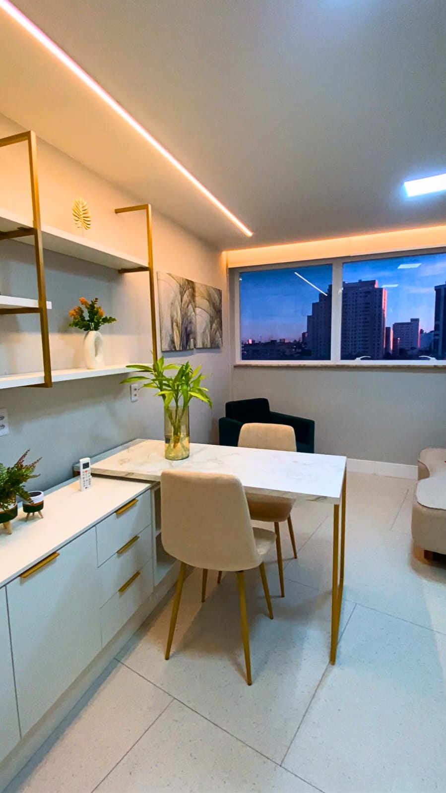 Consultório de psicologia da LIV Saúde Integrativa em Natal com mesa de mármore, cadeiras beges e vista da cidade